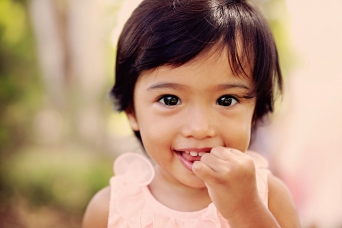 Multiethnic little girl in pink dress - Australian Stock Image