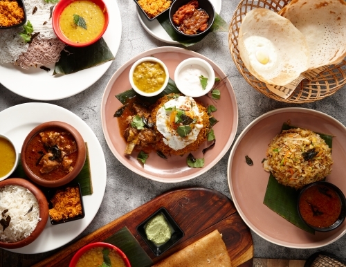 Multiple Indian food dishes on table - Australian Stock Image