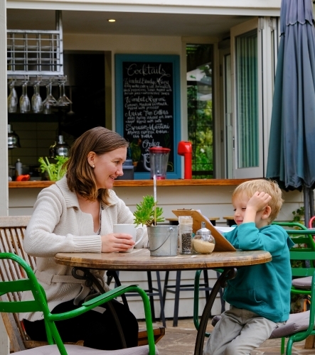 Mum and son looking at a menu in a cafe restaurant - Australian Stock Image