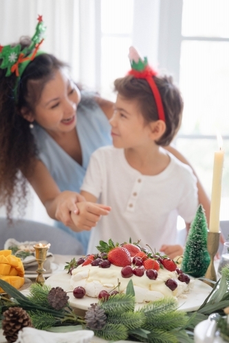 Mum and son wearing Christmas headbands at the table - Australian Stock Image