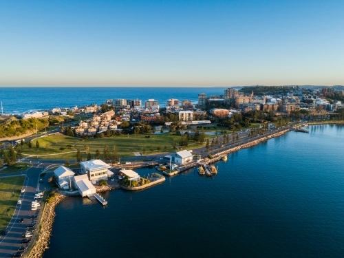 Newcastle Harbour at sunset with last light on seaside buildings on the foreshore - Australian Stock Image