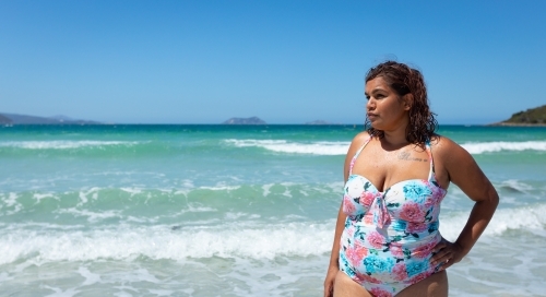 noongar woman wearing floral bathers on the beach - Australian Stock Image