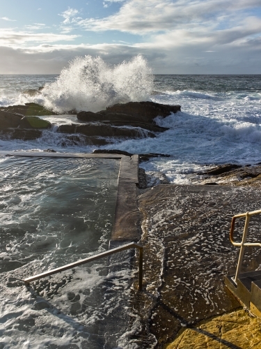 Ocean pool with waves crashing over rocks - Australian Stock Image