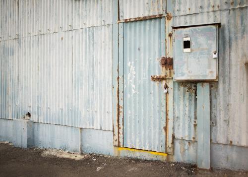 Old faded blue corrugated iron shed and door - Australian Stock Image