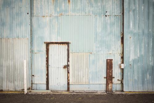 Old faded blue corrugated iron shed and door - Australian Stock Image