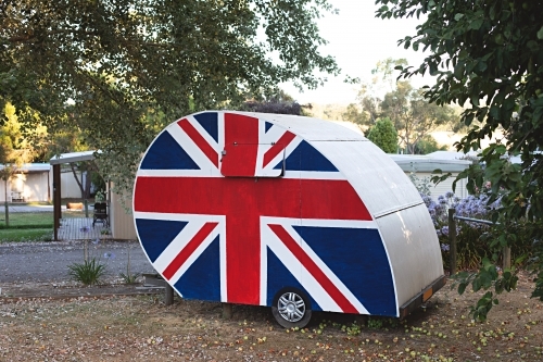 Old-fashioned caravan adorned with the Union Jack, symbolizing British pride - Australian Stock Image