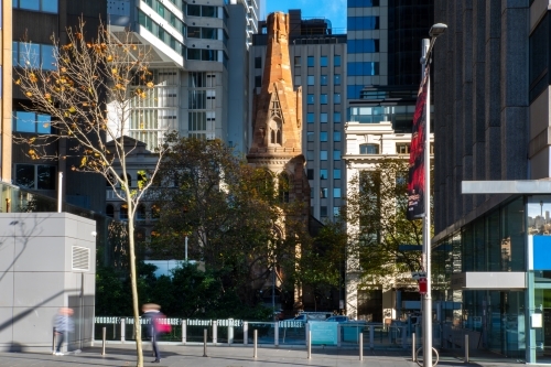 Old sandstone church (St Georges Presbyterian) surrounded by modern buildings - Australian Stock Image