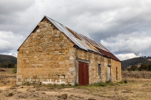 Old stone brick building in a field - Australian Stock Image