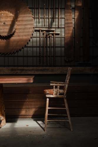 Old vintage wooden chair with industrial timber mill background - Australian Stock Image