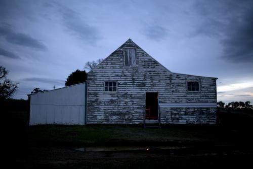 Old white wooden farm shed at dusk