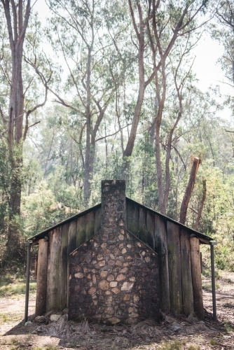 Old wooden shack with brick chimney in the bush