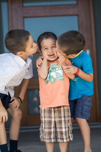 Older brother says goodbye to his siblings on his first day back at school - Australian Stock Image