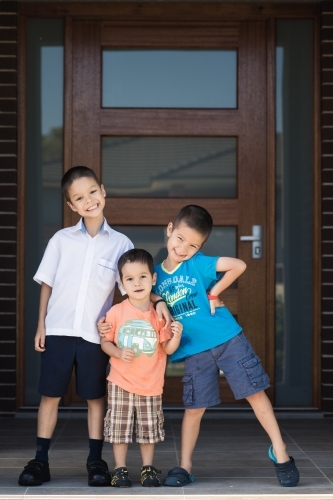 Older brother says goodbye to his siblings on his first day back at school - Australian Stock Image