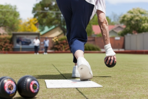 Older woman delivering a lawn bowl - Australian Stock Image