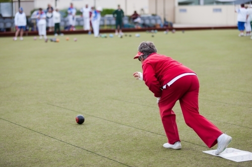 Older woman delivering a lawn bowl - Australian Stock Image