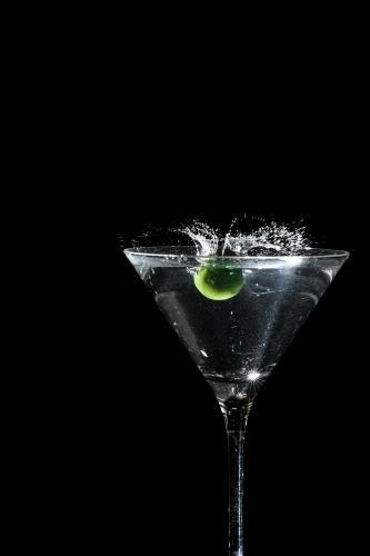 olive splashing into a martini - Australian Stock Image