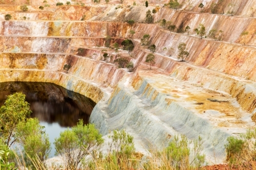 open cut mining with rusty environment and some grass in random places - Australian Stock Image