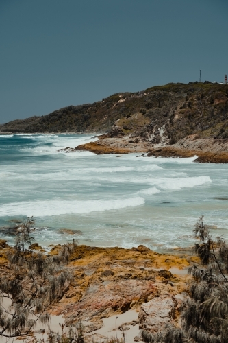 Orange rocks and blue ocean at Honeymoon bay, Moreton Island - Australian Stock Image