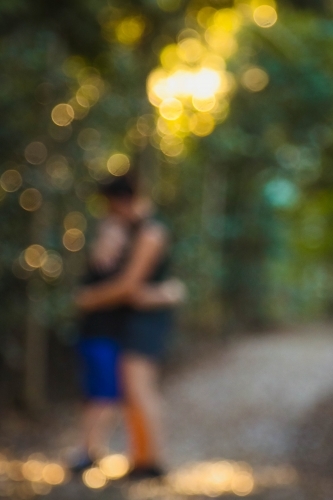 Out of focus background image of mother and son embracing on forest walking track - Australian Stock Image