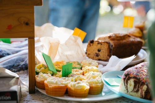 Outdoor display of baked goods like cupcakes and bread. - Australian Stock Image