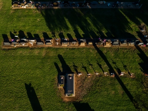 Overhead aerial view of cross shadows on grass at country graveyard - Australian Stock Image