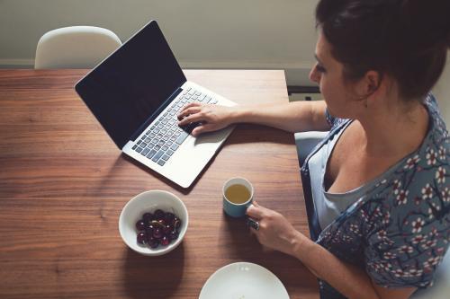 Overhead of a woman working on her laptop at home - Australian Stock Image