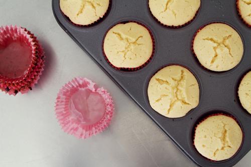 Overhead of cupcakes cooling with used patties beside - Australian Stock Image