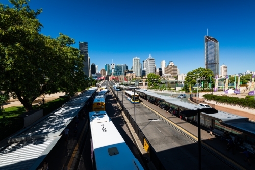Overhead view of buses at bus station leading to bridge and city skyline - Australian Stock Image