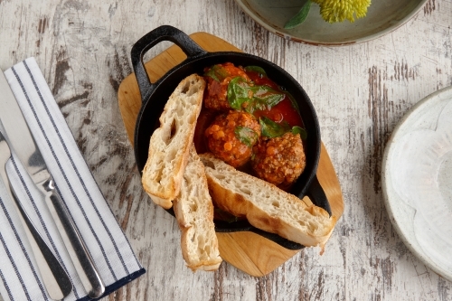 Overhead view of meatballs and bread meal on table - Australian Stock Image