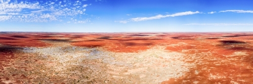 Panorama looking out over red desert land against blue sky - Australian Stock Image