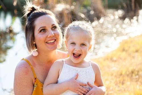 Parent with happy young child outside - Australian Stock Image