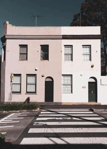 pastel coloured duplex houses overlooking a pedestrian crossing - Australian Stock Image