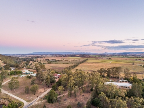 Pastel dusk sky over view of distant farm paddocks and cliff - Australian Stock Image