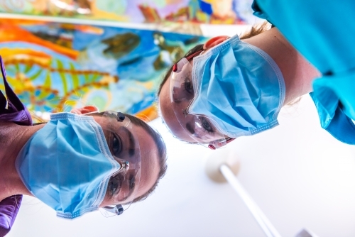 Patient view of dentist and dental assistant - Australian Stock Image