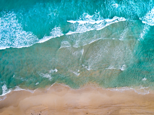 Patterns emerge as waves make way to the shoreline - Australian Stock Image