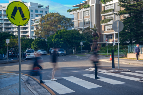 Pedestrian crossing with blurry pedestrians walking across it - Australian Stock Image