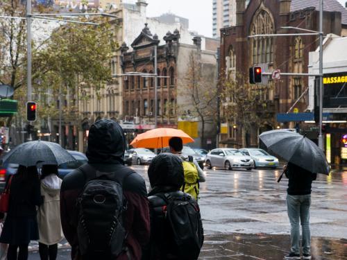 Pedestrians with umbrellas on a wet and cold Sydney day