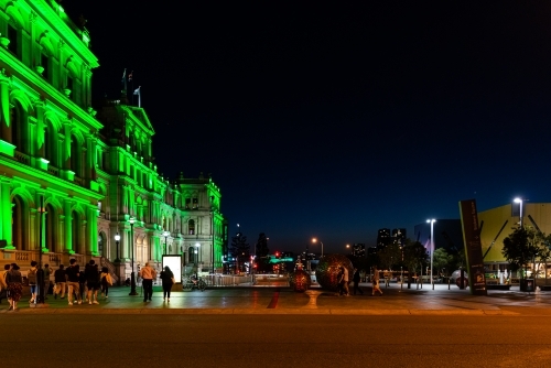 People in a city at night with lit up buildings - Australian Stock Image