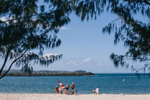 People in distance enjoying a sunny day at the bay - Australian Stock Image