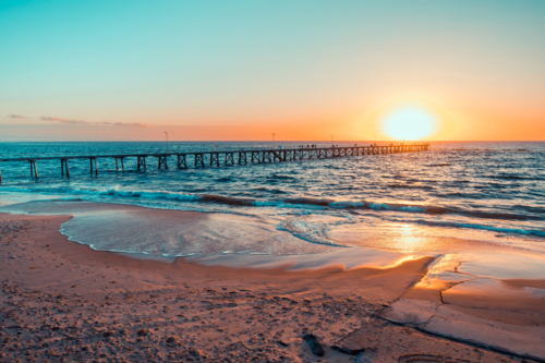 People silhouettes on Port Noarlunga jetty at sunset, South Australia - Australian Stock Image