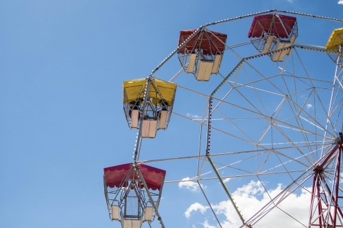 People sitting in carriage of ferris wheel up in air - Australian Stock Image