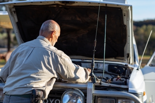 person looking under bonnet of four-wheel-drive vehicle - Australian Stock Image