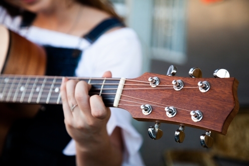 Person playing chords on a guitar - Australian Stock Image
