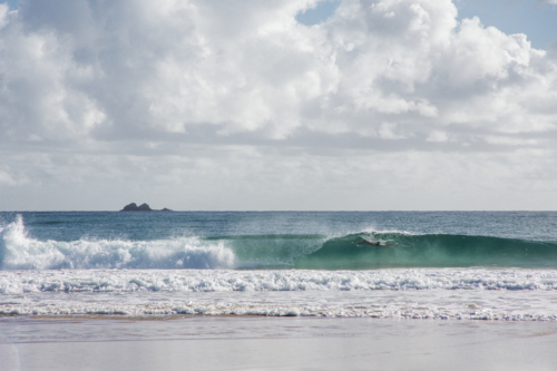 Person swimming in wave breaking at Byron Bay - Australian Stock Image