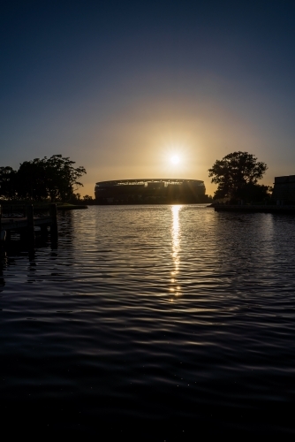 Perth AFL Stadium. Sunrise over water and silhouettes - Australian Stock Image