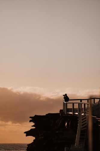 Photographer silhouette at the Bronte Beach headland at sunrise - Australian Stock Image