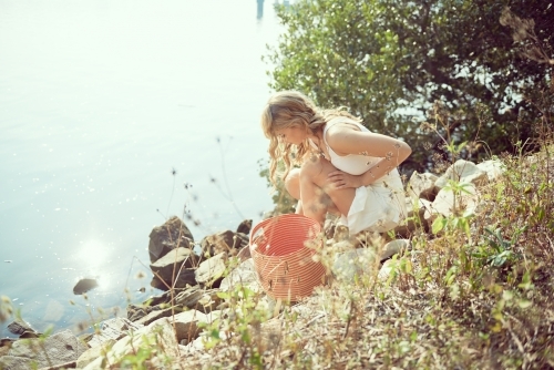 Picking flowers from stones by the water on a summer day