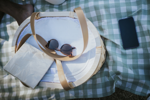 Picnic basket on a picnic blanket with sunglasses - Australian Stock Image