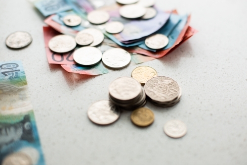 piles of coins with more money in the background - Australian Stock Image