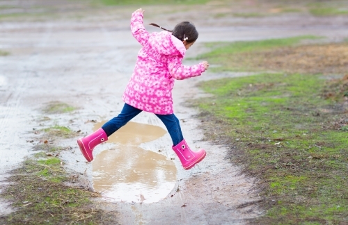 Pink gumboots, pink raincoat, wet weather - Australian Stock Image